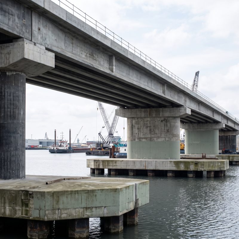 Concrete bridge piers and deck spanning water at a working port